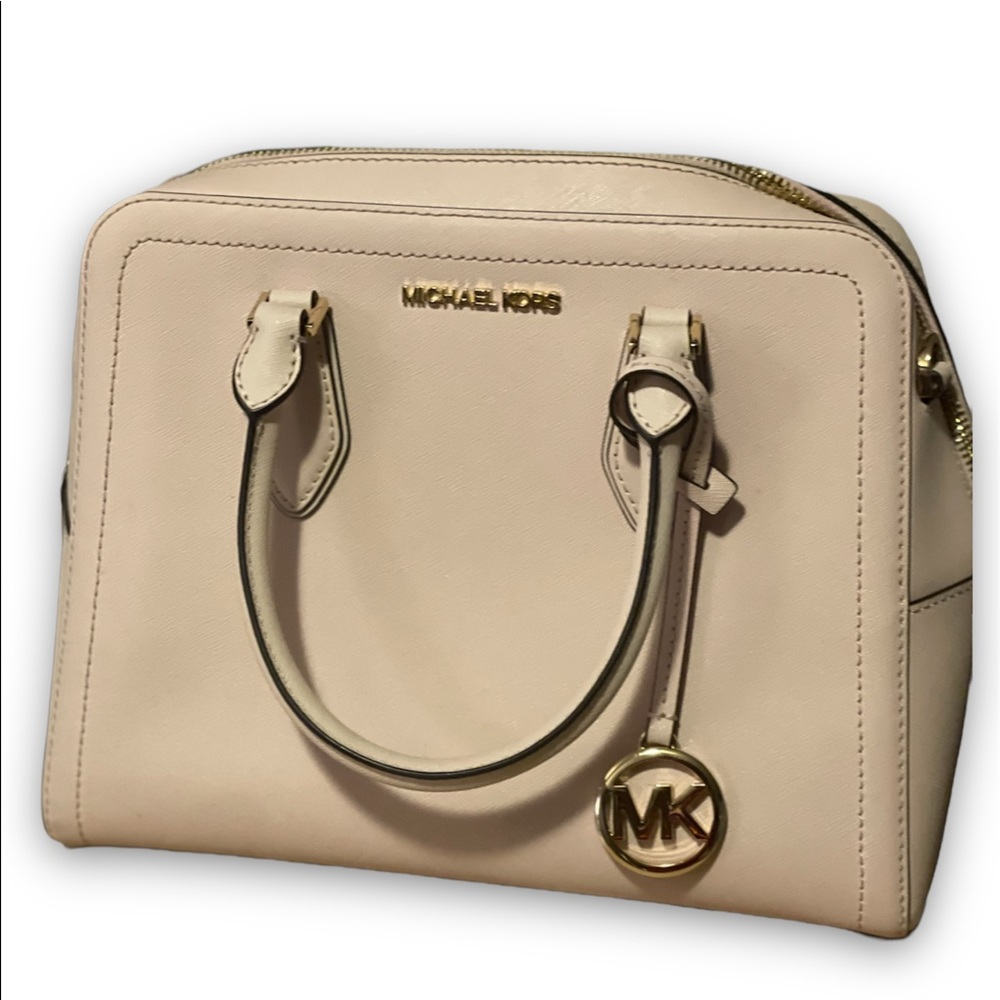 This is a beautiful light pink Michael kors purse with a gold Label and tag.